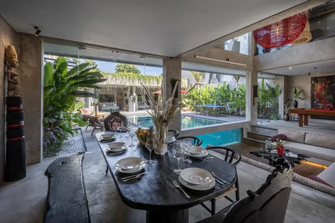 Indoor-outdoor dining overlooking the pool at Concrete Serenity
