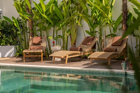 Poolside loungers framed by tropical planting at Villa Soluna